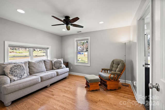 living room featuring ceiling fan and light hardwood / wood-style flooring