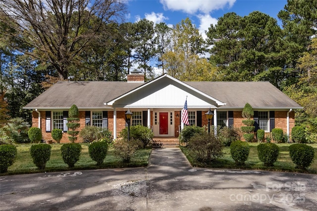 ranch-style home with brick siding and a chimney