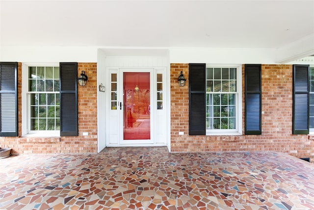 view of exterior entry with brick siding