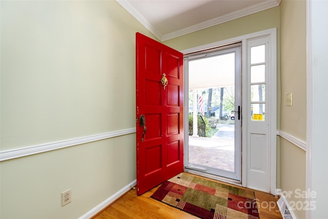 entrance foyer with light wood-style floors, visible vents, baseboards, and crown molding