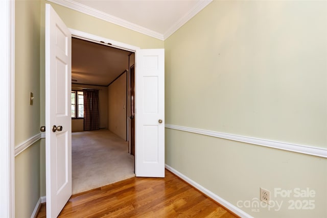 hall with ornamental molding, carpet, baseboards, and wood finished floors