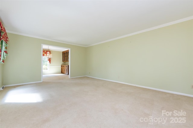 empty room with an inviting chandelier, baseboards, ornamental molding, and light colored carpet