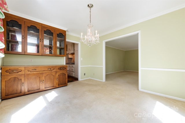 unfurnished dining area featuring light carpet, baseboards, a notable chandelier, and crown molding