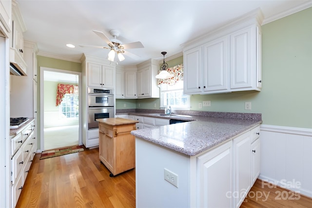 kitchen featuring a peninsula, white cabinetry, and stainless steel appliances