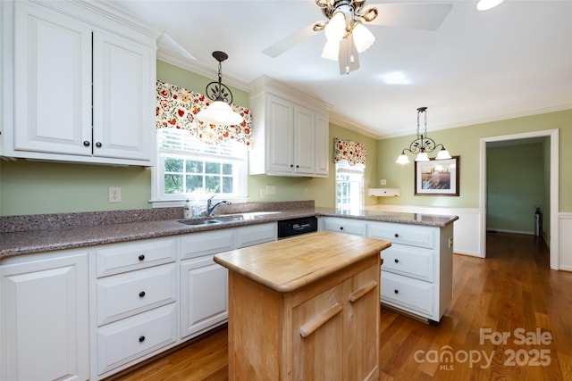 kitchen with a peninsula, a sink, and white cabinets