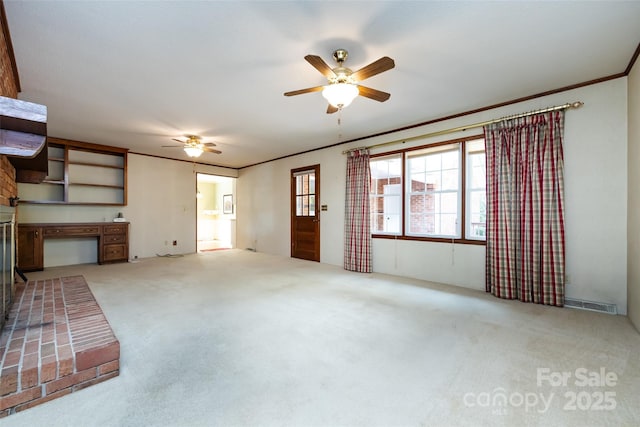 unfurnished living room featuring ceiling fan, ornamental molding, visible vents, and light colored carpet