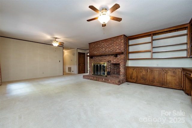 unfurnished living room with a brick fireplace, light colored carpet, ceiling fan, and visible vents