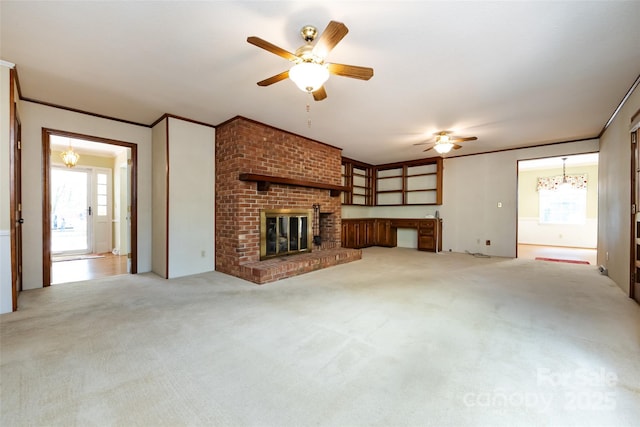 unfurnished living room featuring ornamental molding, light carpet, a fireplace, and ceiling fan