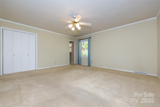 unfurnished bedroom with light colored carpet, visible vents, and crown molding