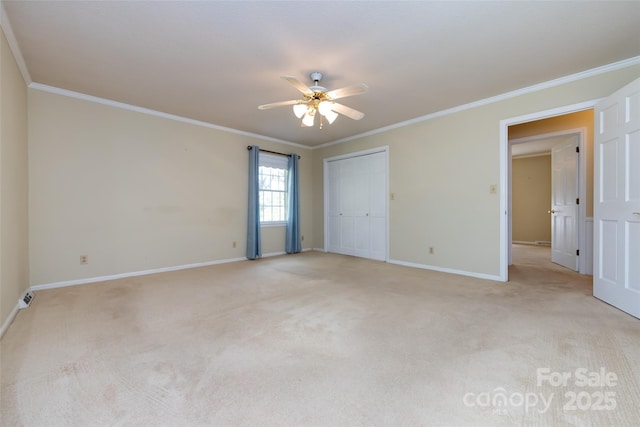 empty room featuring light colored carpet, crown molding, baseboards, and ceiling fan