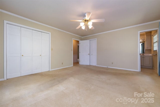 unfurnished bedroom with baseboards, ornamental molding, two closets, and light colored carpet