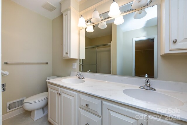 full bath with double vanity, an enclosed shower, visible vents, and a sink