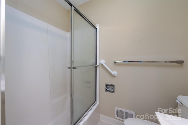 bathroom featuring toilet, visible vents, and enclosed tub / shower combo