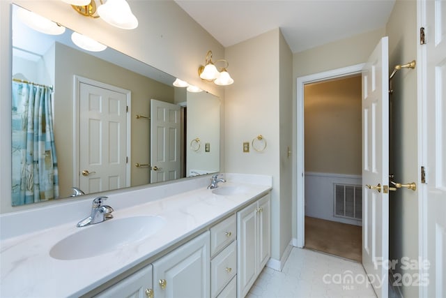 full bathroom with double vanity, visible vents, and a sink