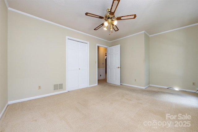 unfurnished bedroom featuring light carpet, baseboards, visible vents, ornamental molding, and a closet