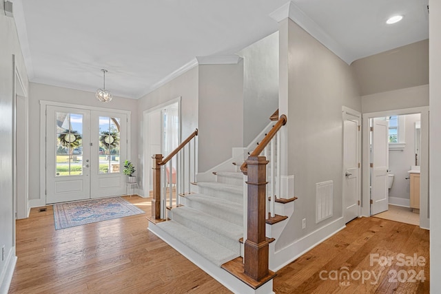 foyer with a wealth of natural light, french doors, and light hardwood / wood-style floors