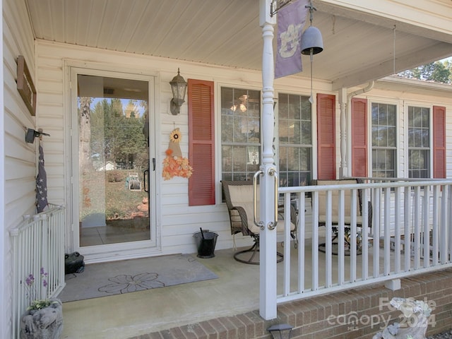 view of exterior entry featuring covered porch