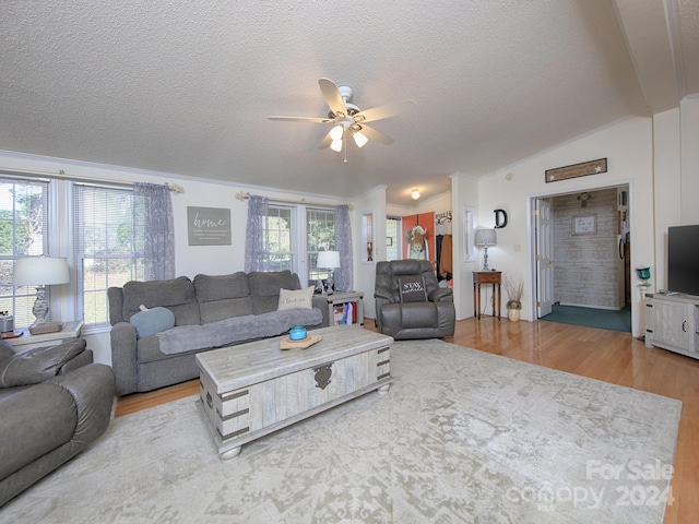 living room featuring lofted ceiling, hardwood / wood-style floors, a textured ceiling, and ceiling fan