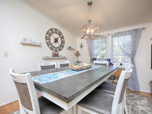 dining area with ornamental molding, a textured ceiling, and hardwood / wood-style floors