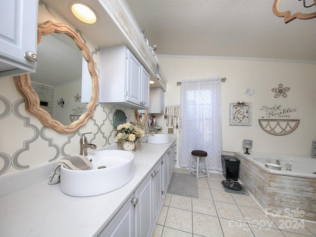 bathroom with tile patterned flooring, a bathing tub, ornamental molding, vanity, and a textured ceiling