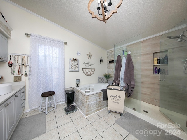 bathroom with tile patterned flooring, plus walk in shower, vanity, and a textured ceiling