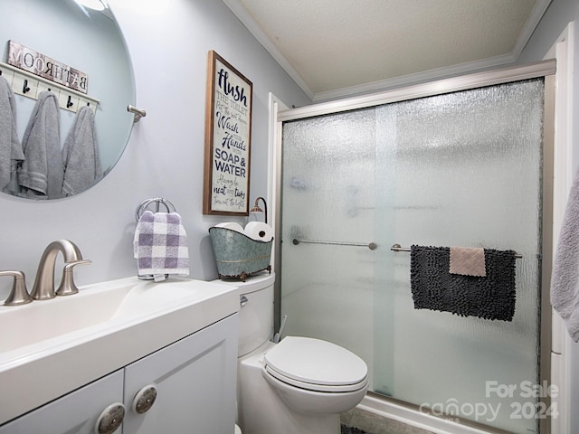 bathroom with ornamental molding, vanity, toilet, and a shower with shower door