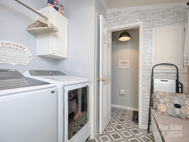 laundry room with crown molding, washer and clothes dryer, and cabinets