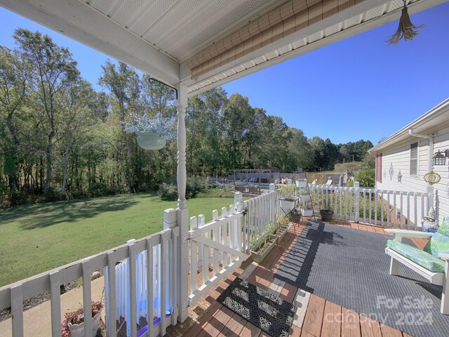 wooden terrace featuring a lawn