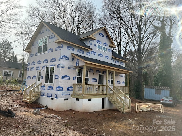 property under construction featuring a porch and a storage shed