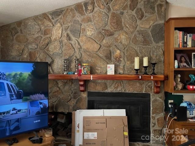 interior details with a stone fireplace and a textured ceiling