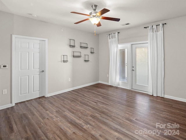 empty room with ceiling fan and dark hardwood / wood-style flooring