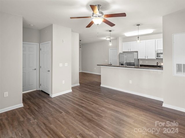 unfurnished living room with dark hardwood / wood-style flooring and ceiling fan