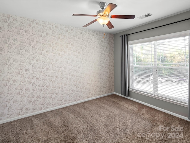 spare room featuring ceiling fan and carpet flooring