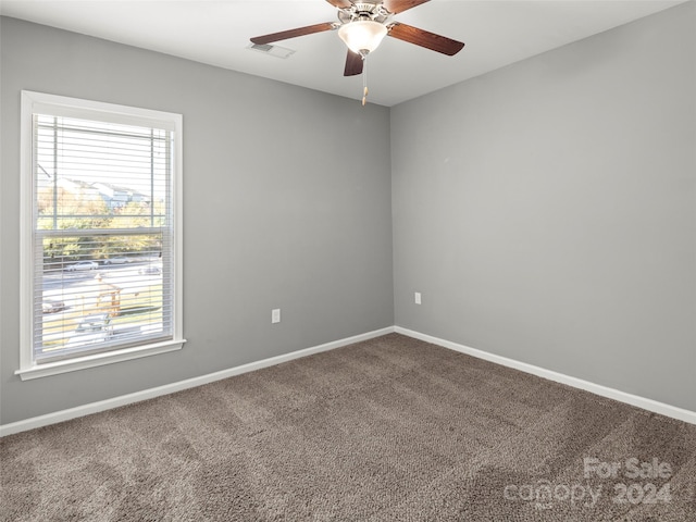 carpeted spare room featuring ceiling fan