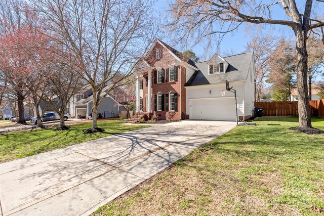 view of front of house with an attached garage, brick siding, fence, concrete driveway, and a front yard