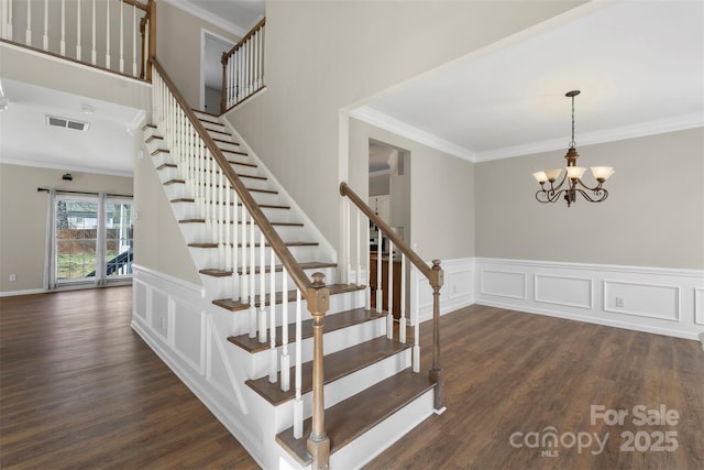 stairway featuring crown molding and wood finished floors