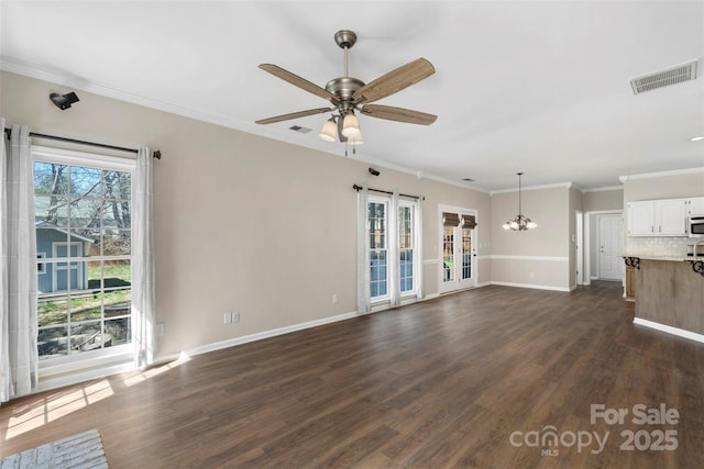 unfurnished living room featuring dark wood-style flooring, visible vents, ornamental molding, baseboards, and ceiling fan with notable chandelier