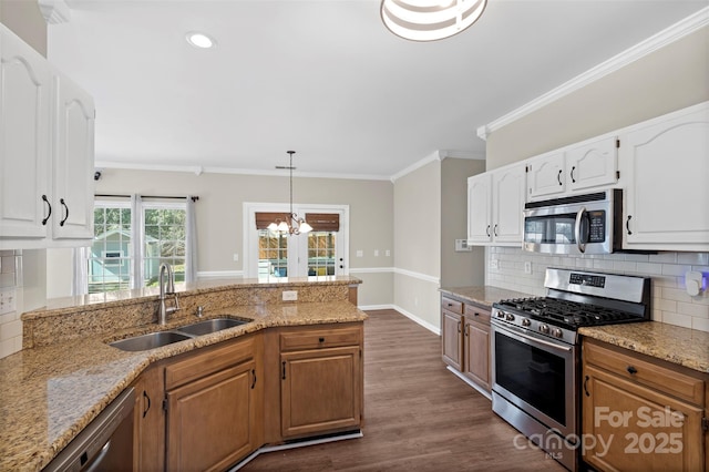 kitchen featuring light stone countertops, ornamental molding, stainless steel appliances, and a sink