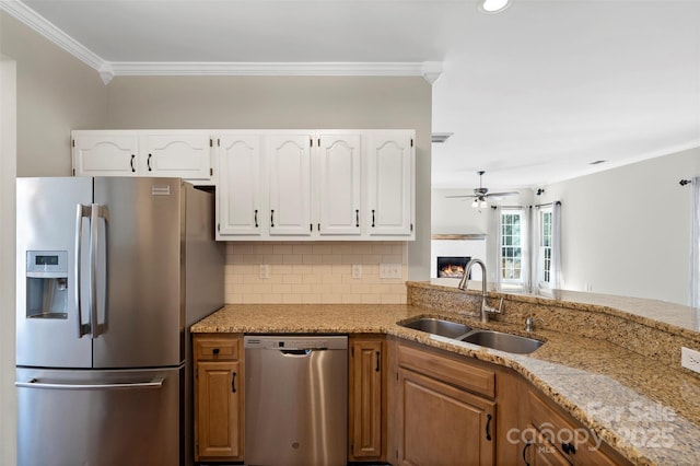 kitchen featuring stainless steel appliances, tasteful backsplash, a sink, and light stone countertops