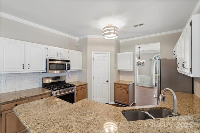 kitchen featuring stainless steel appliances, a sink, visible vents, white cabinets, and light stone countertops