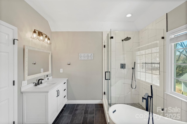 full bathroom with lofted ceiling, a stall shower, vanity, a freestanding tub, and baseboards