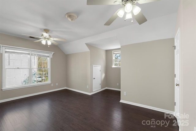 interior space featuring visible vents, dark wood-type flooring, a ceiling fan, vaulted ceiling, and baseboards