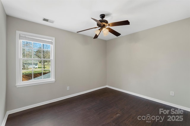 unfurnished room with ceiling fan, dark wood-style flooring, visible vents, and baseboards