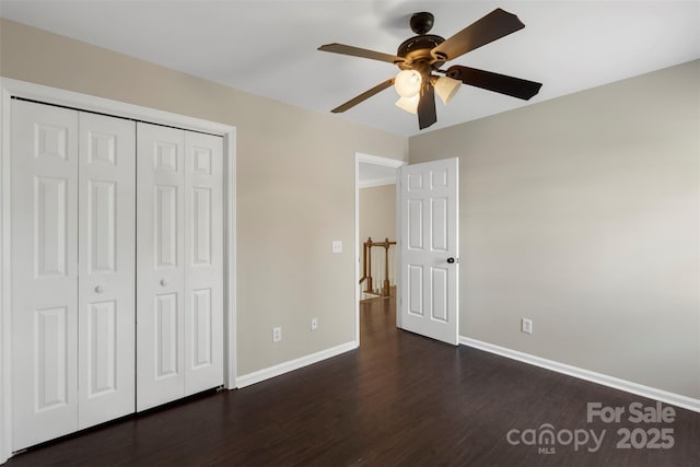 unfurnished bedroom featuring dark wood-style floors, a closet, a ceiling fan, and baseboards