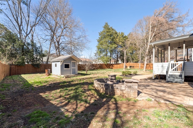 view of yard featuring a storage shed, a fenced backyard, and an outdoor structure