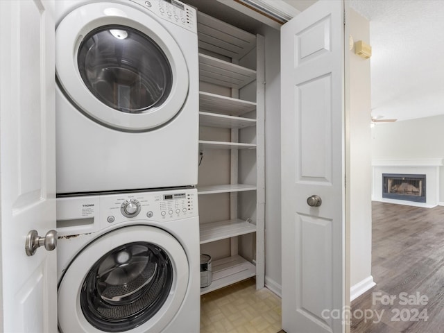 washroom with light hardwood / wood-style flooring and stacked washer and dryer