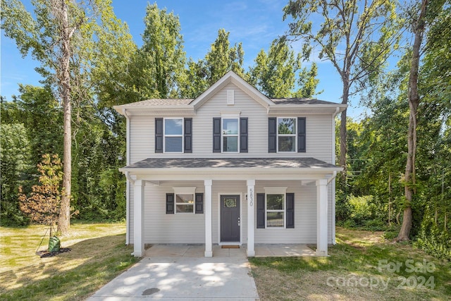 front facade featuring covered porch and a front yard