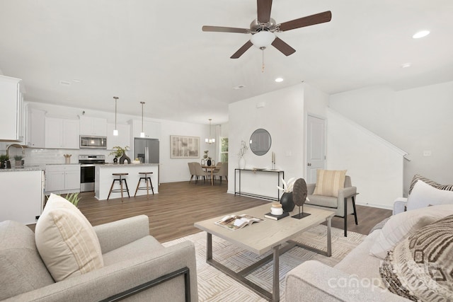 living room with sink, light wood-type flooring, and ceiling fan