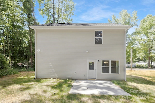 rear view of property with a patio and a lawn