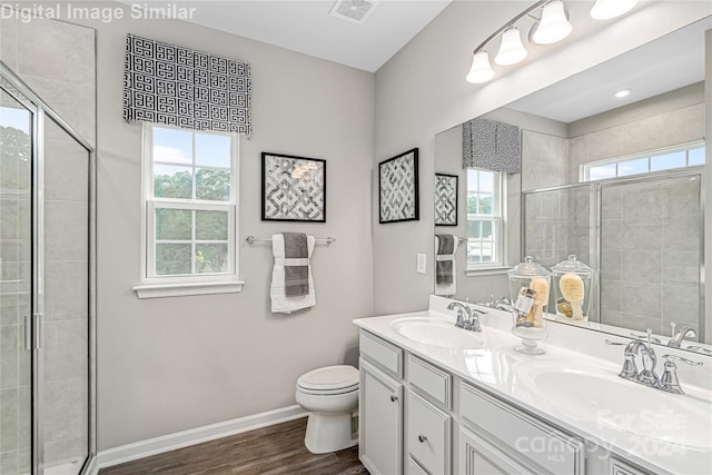 bathroom with vanity, hardwood / wood-style flooring, a shower with shower door, and toilet